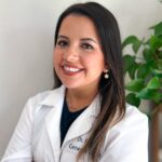 Smiling woman in a white lab coat.
