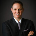 Here's an alt tag for the image: `Headshot of a man in a suit`