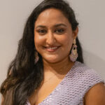 Here's an alt tag for the image: Smiling woman with long dark hair.