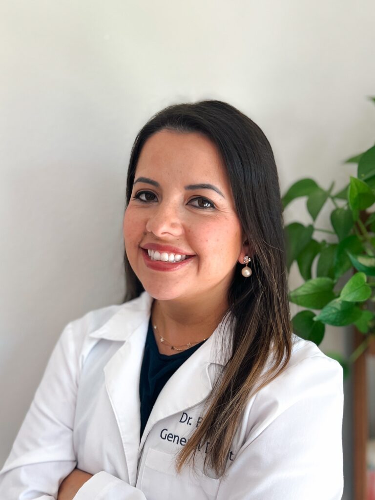 Smiling woman in white medical coat.